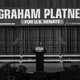 Black-and-white photo of an empty podium in front of a stage and a "Graham Platner for U.S. Senate" sign.