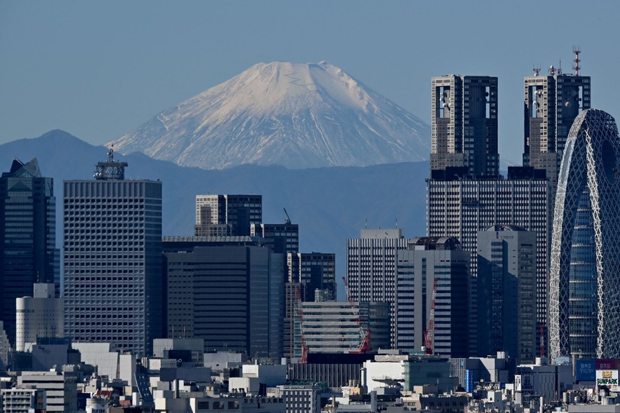 Mount Fuji, seen in the distance between skyscrapers in Tokyo