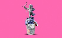 A statue of cupid on top of a basket of laundry