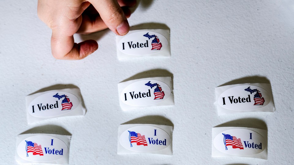 "I Voted" stickers, some with an American flag and some with an outline of Michigan