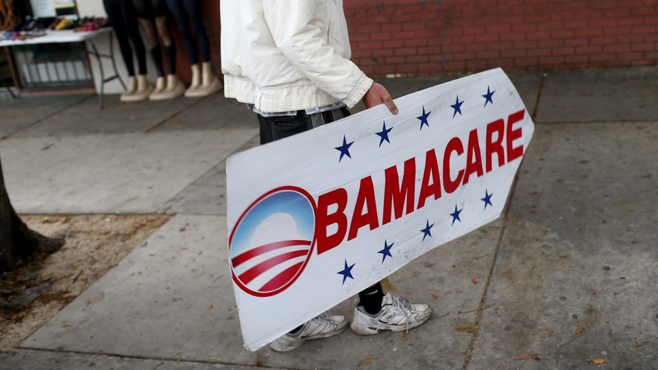 A person holds an Obamacare sign