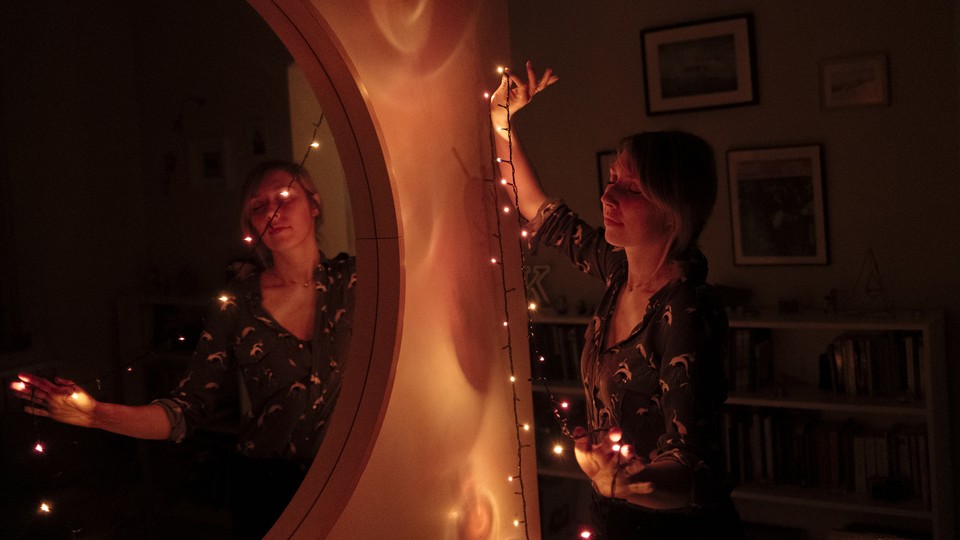 A woman wrapped in Christmas lights