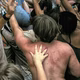 A color photograph of sweaty, dancing people in a moshpit