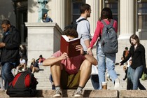 A person reads on a college campus