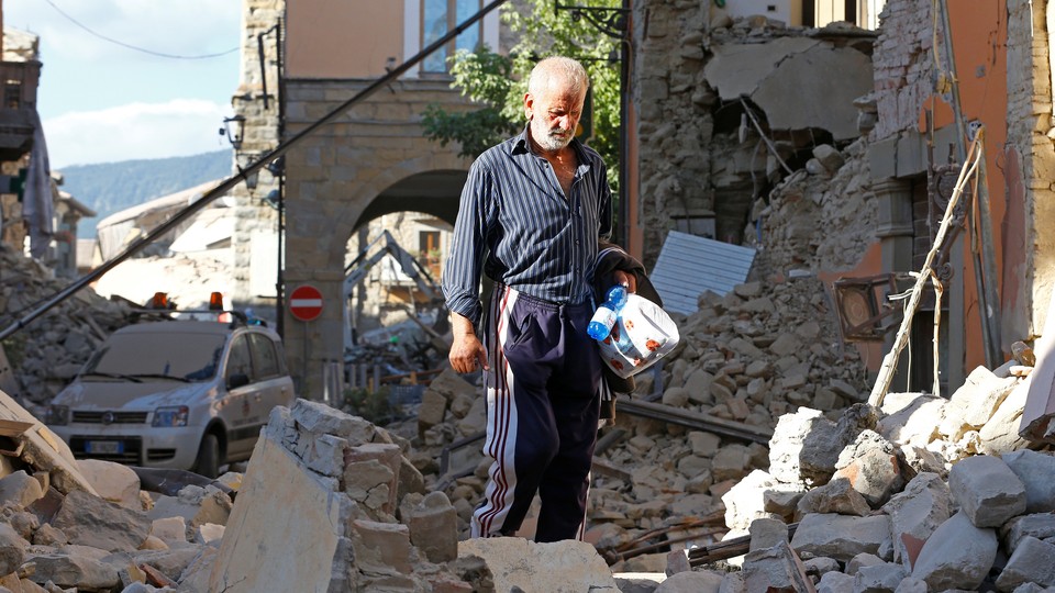 A man walks through rubble following an earthquake in Amatrice.