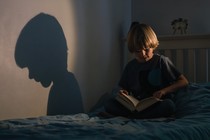 child reading a book alone in their bedroom