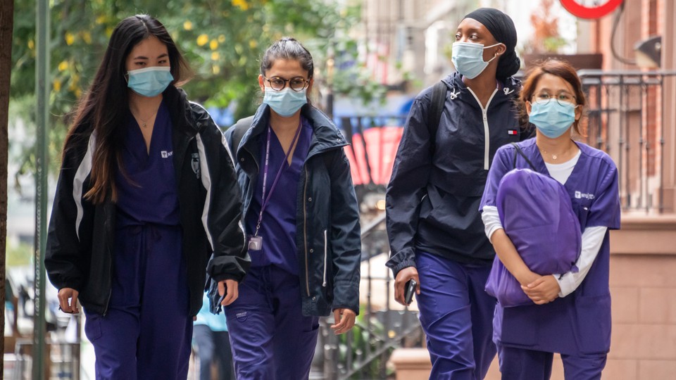 Medical workers walk near NYU Langone Health hospital in New York City on September 29, 2020