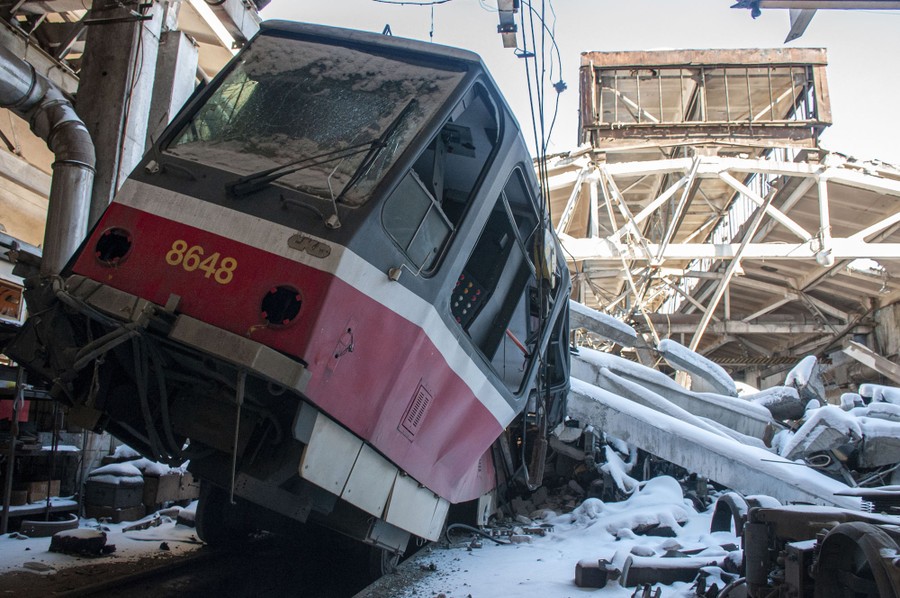 A damaged tram sits among the rubble of a tram depot.