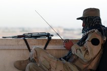 A private security organization contractor listens to a radio during his duty at guard tower in Camp Nathan Smith in Kandahar City May 7, 2010.