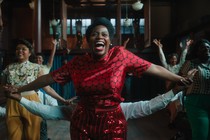 Fantasia Barrino wearing a red dress and red lipstick in "The Color Purple"
