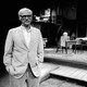 A black-and-white photograph of Arthur Miller in front of a play set