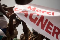 People holding a "Merci Wagner" sign