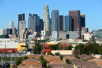 Single-family homes sit in front of the Los Angeles skyline