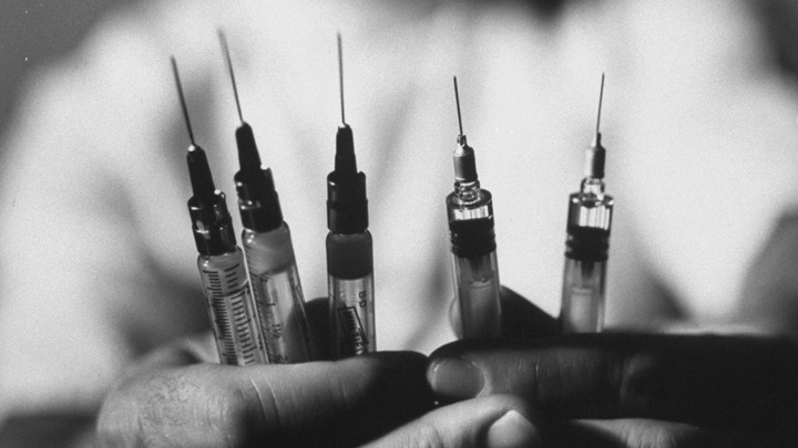 A man holding syringes