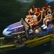 People on Stardust Racers, a purple and blue roller coaster with red chairs at Universal Epic Universe