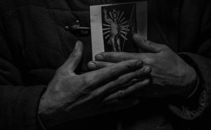 Close-up of hands holding a religious image