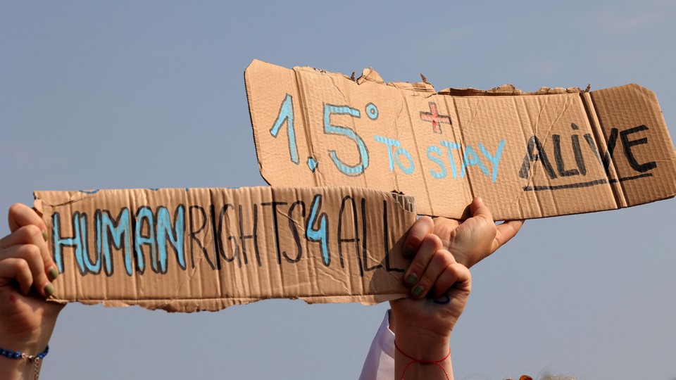 An image of a protest sign that reads "1.5 degrees to stay alive."