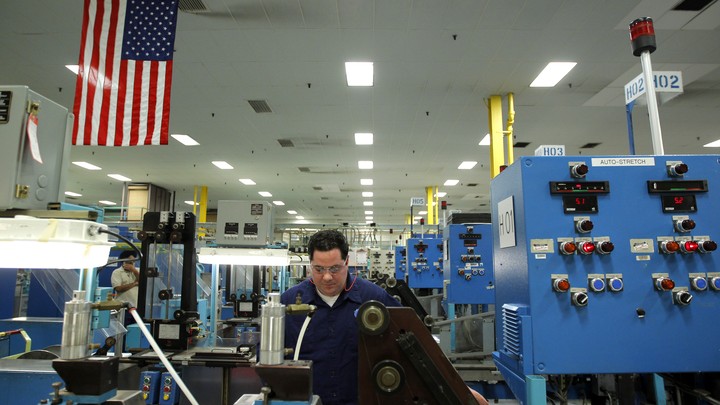 A man works in a factory among several machines.