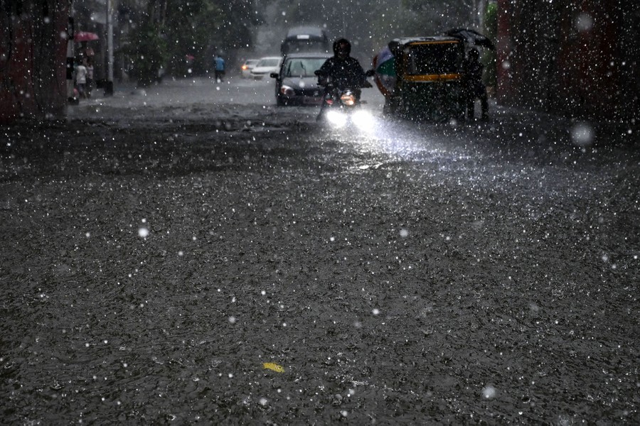 Motorists make their way through a waterlogged street.