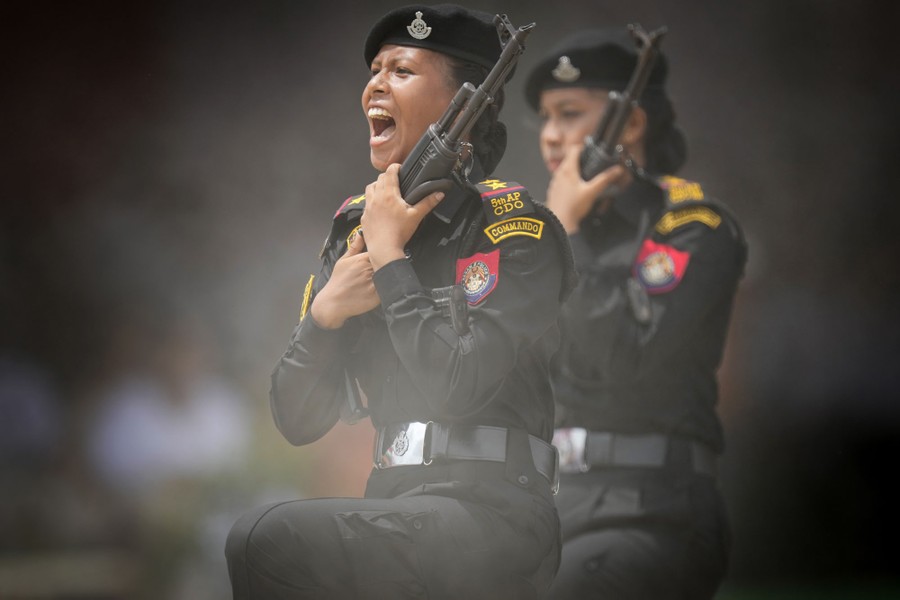 Two police officers shout and march in a parade.