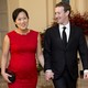 Mark Zuckerberg and Priscilla Chan walk while holding hands and wearing formalwear.