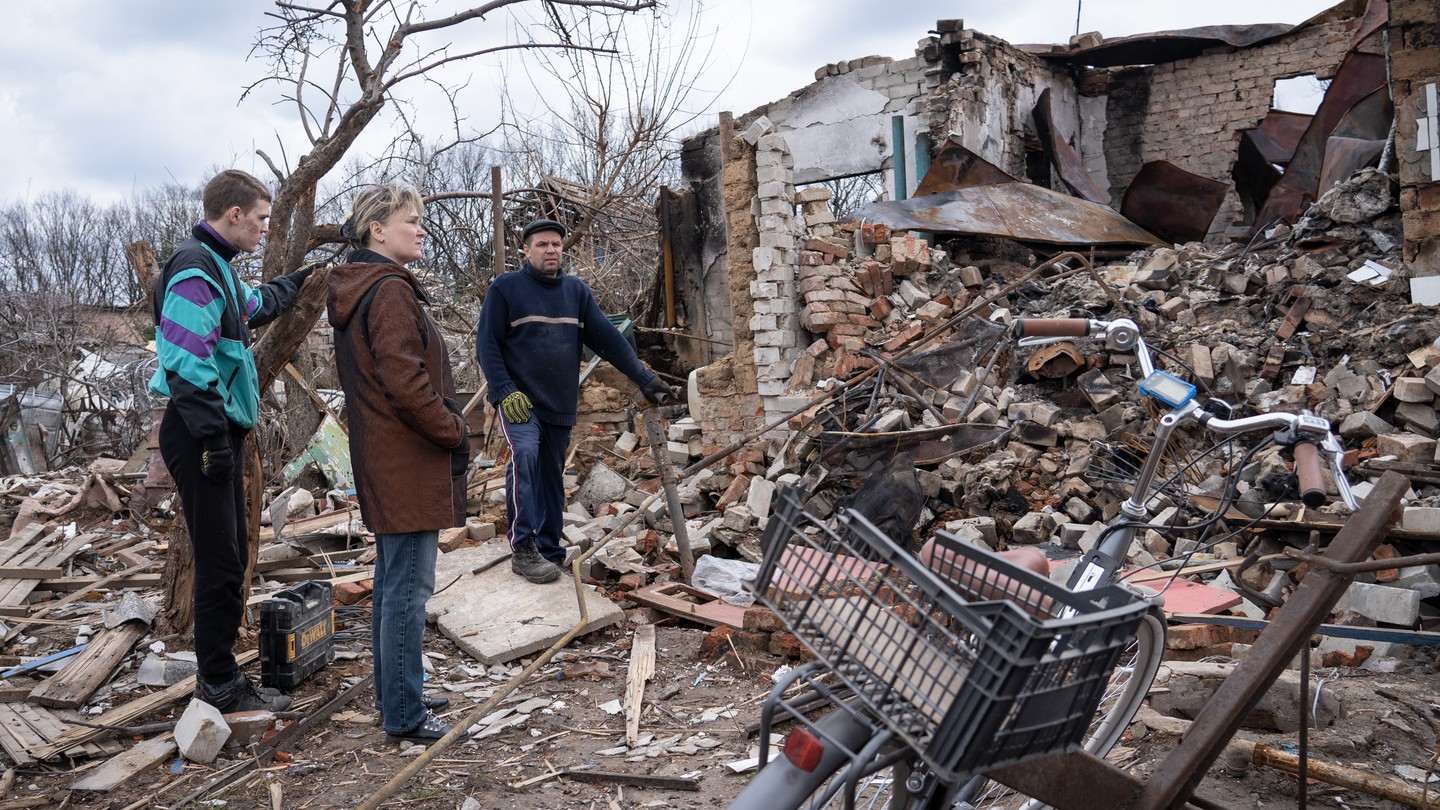 Residents stand outside a building on the outskirts of Chernihiv