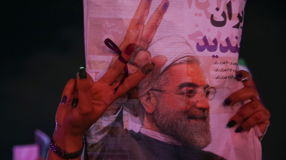 A supporter of Iranian president Hassan Rouhani holds his poster as she celebrates his victory in the presidential election, in Tehran, Iran, on May 20, 2017.