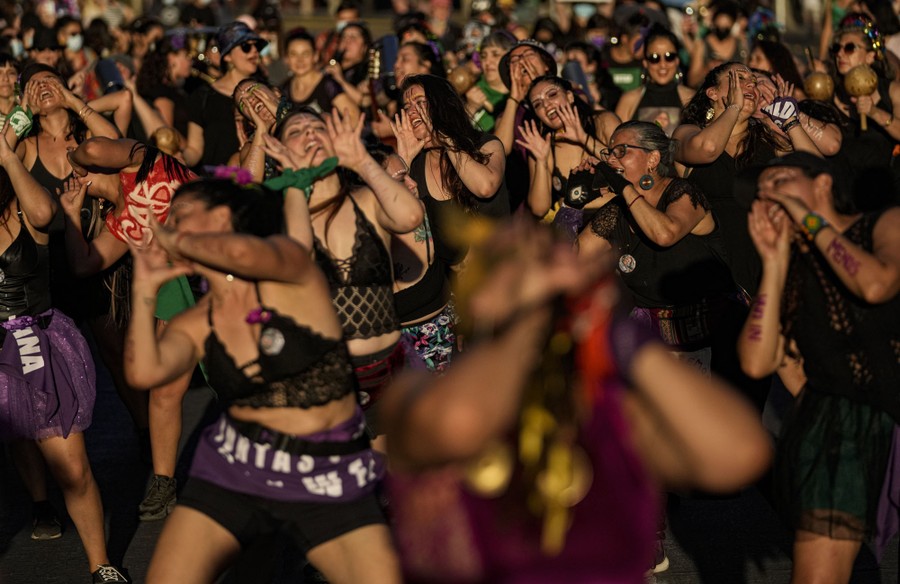 Dozens of women dance together during a demonstration.