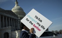 A person holds a sign in front of the Capitol that reads, "TikTok changed my life for the better."