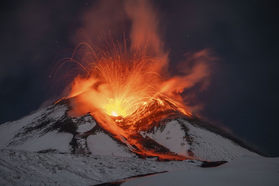 Lava erupts from the snow-covered Mount Etna.