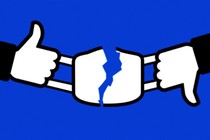 Facebook thumbs-up and thumbs-down logos, ripping apart a face mask.