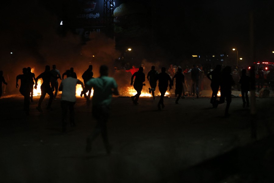 Demonstrators run from tear gas.