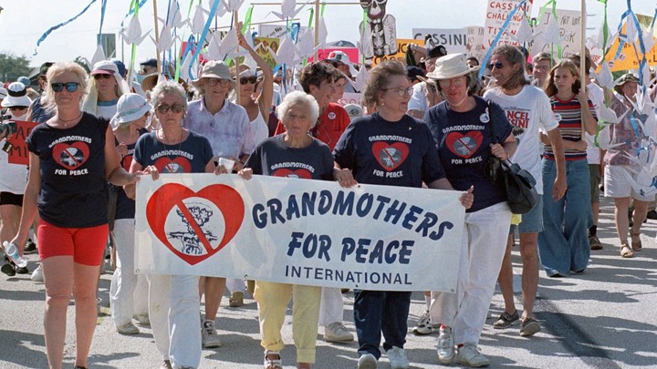Protesters hold a sign that says "Grandmothers for Peace International"