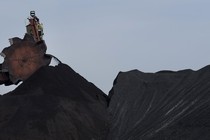 A large machine with a round head loads coal into piles at a coal plant in Letart, West Virginia.