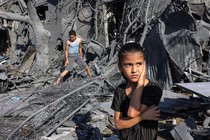 A girl stands amid rubble outside a bombed-out building in Rafah.