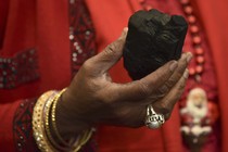 A woman holds a lump of coal