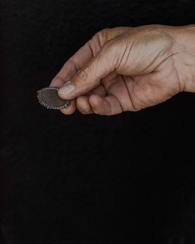 A hand holding a sample of cobalt
