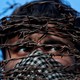 A masked Kashmiri man with his head covered with barbed wire attends a protest in Srinagar.