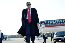 Donald Trump walks away from an airplane that reads "Trump."