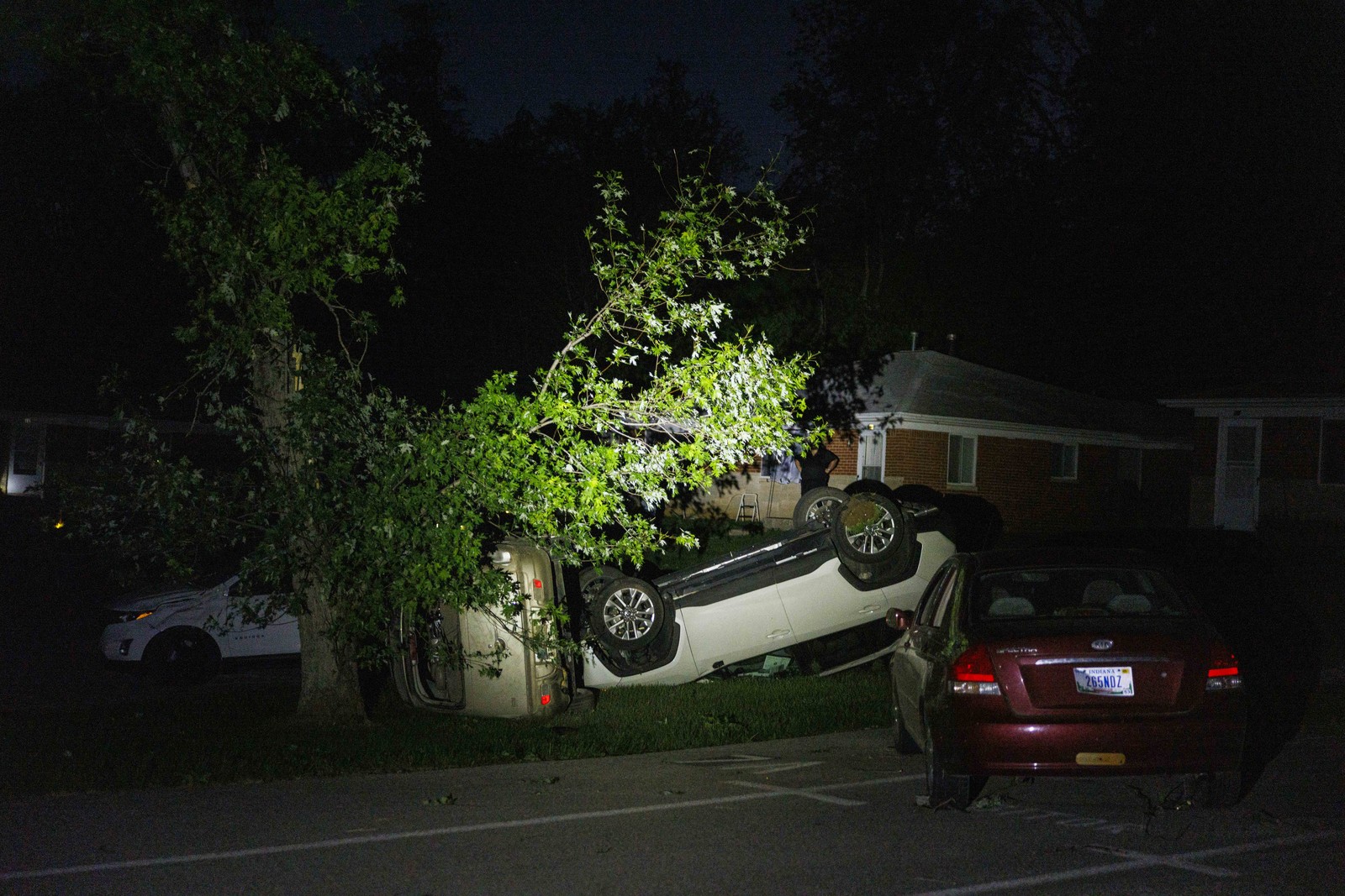 Several cars lie upside down or on their sides, flipped over by a tornado.