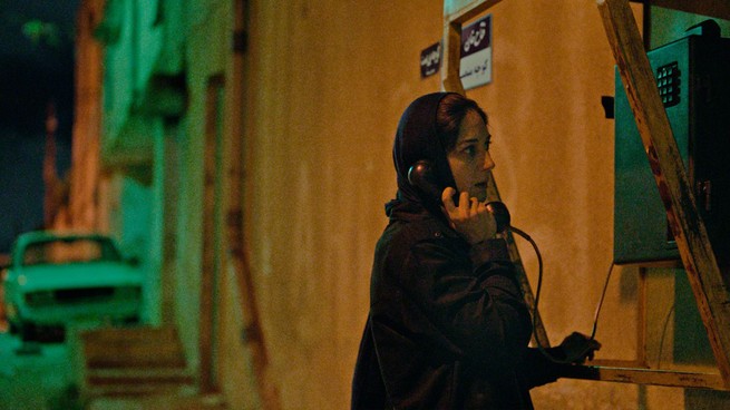 A woman holding a telephone to her ear in "Holy Spider"
