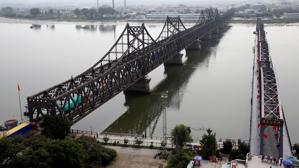 Vehicles cross a bridge connecting North Korea and China