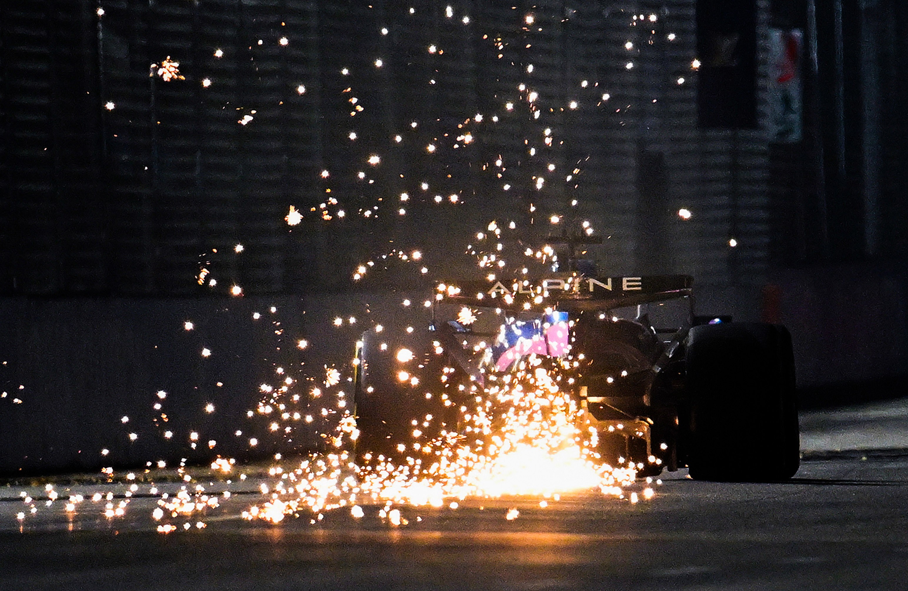 Sparks fly behind an F1 racing car.