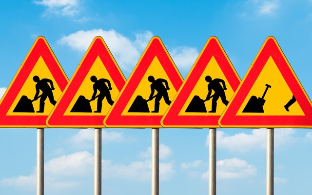 A set of five construction signs with a construction worker on each. The last sign shows the worker running away from his work.