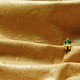 A miniature figurine of a man sits perched on what looks like folds of leather.