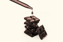 An image of chocolate squares with a lab dropper above them.