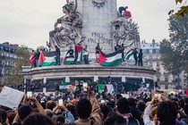 A pro-Palestinian protest including flags and signs encircles the statue at the center of Place de la Republique, in Paris.