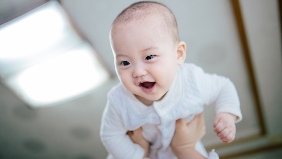 A young baby being held in the air