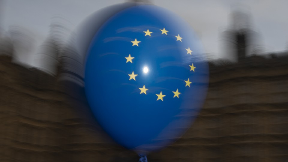 EU balloons are waved by anti Brexit campaigners outside the Houses of Parliament in London.