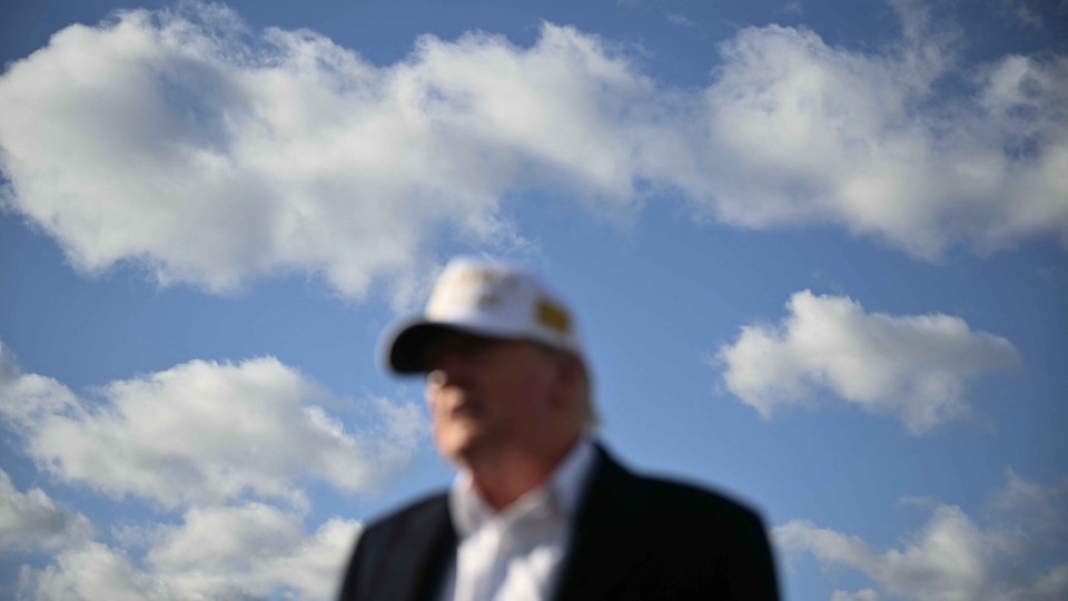 US President Donald Trump is out of focus in the photo, while the blue cloudy sky behind him is in focus